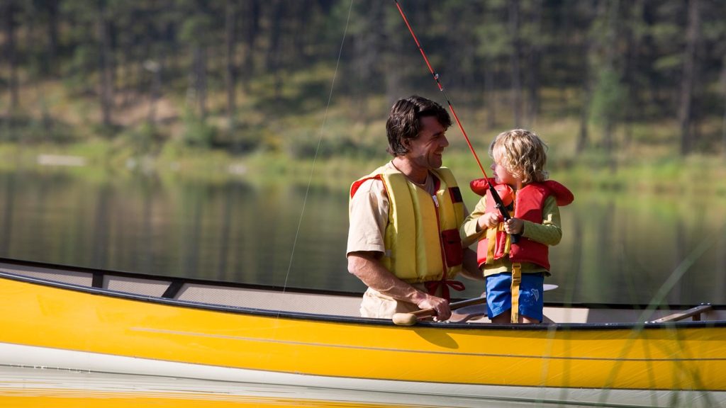 father and son fishing in canoe